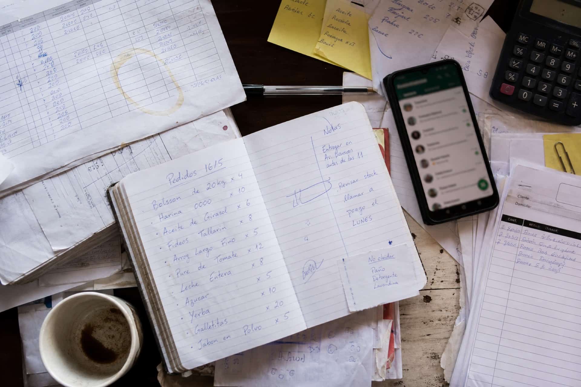 Pedidos, notas y WhatsApp en un escritorio — el trabajo todavía a mano